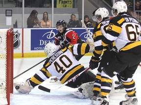 Kingston Frontenacs goalie Lucas Peressini dives for the puck as Niagara IceDogs’ Jesse Graham moves in on net while Kingston’s Sam Bennett (93) and Dylan DiPerna take up position in front of the net during Friday night’s Ontario Hockey League game at the Rogers K-Rock Centre. (Michael Lea/The Whig-Standard)