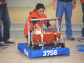 Ruhmaa Bhatti, captain of the robotics team at London's Sir Wilfrid Laurier Secondary School, tinkers with a Frisbee-tossing robot in the courtyard at Parkside Collegiate Institute in St. Thomas on Thursday. Laurier built the robot with help from Western University engineering students and its team visited Parkside to drum up interest in its own robotics team.