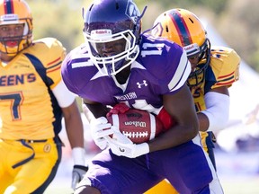 Yann Dika-Balotoken of Queen?s tackles Western receiver George Johnson during Saturday?s OUA football game at TD Stadium. (DEREK RUTTAN, The London Free Press)