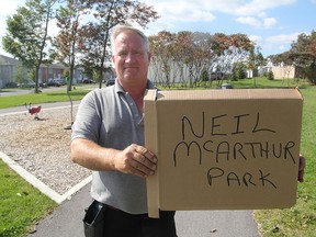 Kevin McArthur with his makeshift sign to mark Neil McArthur Park. (Michael Lea The Whig-Standard)