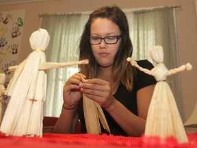 Queen's University student Lacey Taylor starts work on a new faceless doll made out of corn husks during a project at the Four Directions Aboriginal Centre to remember the 600 aboriginal women missing or killed in Canada in recent years. (Michael Lea The Whig-Standard)