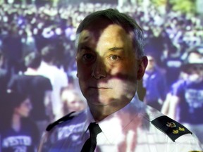 London Deputy Police Chief Brent Shea stands in front of a video showing a large crowd of homecoming revellers on Broughdale Ave., shot by police on Saturday. (CRAIG GLOVER, The London Free Press)