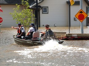 RCMP and Fish and Wildlife officers patrol the flooded Hampton Hills area in High River in July. (QMI AGENCY/File)