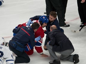 Team officials and teammates help George Parros of the Montreal Canadiens after he was injured in a fight with the Toronto Maple Leafs' Colton Orr Tuesday night in Montreal.
QMI Agency