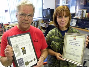 Trenton Legion Branch 110 historian Doug Lawrence holds the Burtt brothers collection obtained by the Legion thanks to the efforts of Cpl. Karen Neate. She raised the money needed to prevent the artifacts from being auctioned on eBay. The  Legion presented Neate with a certificate of appreciation Friday.