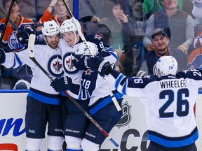 Oct 1, 2013; Edmonton, Alberta, CAN; Winnipeg Jets defender Jacob Trouba (8) celebrates his goal with teammates Andrew Ladd (16) , Blake Wheeler (26) and Bryan Little (18) during the third period against the Edmonton Oilers at Rexall Place. Winnipeg Jets won 5-4. Mandatory Credit: Sergei Belski-USA TODAY Sports