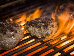 Premium beef burgers flame broiled on a gas grill. (Fotolia.com)