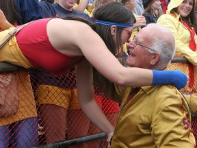 Queen's University fourth-year phys-ed student Tosha Lobsinger, in the stands, gives a hug to Rolly White (Sci '54) as alumni parade the track at Richardson Stadium at half-time of the Homecoming game during Homecoming in 2008.