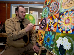 Paul Moyst, a client of the Community Connections Recovery Program of Providence Care does a touch up to some art he helped create at the Hope and Discovery Artisans group workshop at 533 Montreal St. (Ian MacAlpine The Whig-Standard)