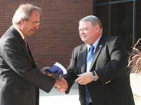 Mayor Randy Hope accepts the flag of Kentucky from John Trowbridge, Command Historian for the Kentucky National Guard, during a ceremony held in front of the Chatham-Kent Civic Centre on Oct. 4.