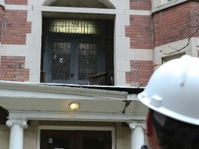 A Toronto building inspector takes photos of a balcony at 1 Glen Rd. where woman was critically injured in a fall. (DAVE THOMAS/Toronto Sun)