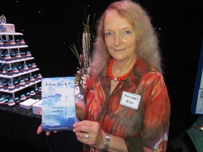 Margaret Bird holds a copy of A River Runs By It, an anthology of writing about Sarnia officially released Sunday at an event held at The Imperial Theatre. (PAUL MORDEN, The Observer)