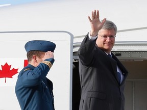 Canada's Prime Minister Stephen Harper waves as he boards a Royal Canadian Air Force plane before departing for Asia in Ottawa October 3, 2013. Harper is traveling to Malaysia and Indonesia. REUTERS/Chris Wattie