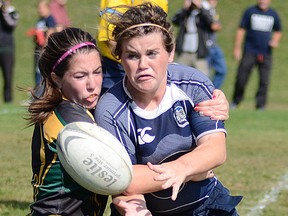 Quinte's Megan Weinhold off-loads while being tackled by Centennial's Amy Stather during Saturday's Saints Fall Classic senior girls rugby match at Paul Paddon Field. (Carly Donaldson for The Intelligencer)