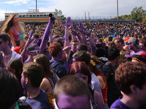 Queen’s University students celebrate on the field during the halftime of a Golden Gaels football game during Homecoming 2013. (Elliot Ferguson/Whig-Standard file photo)