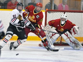 Tyler Pauli (21) of the Mitchell Hawks battles for position with Josh Steffler (24) of the visiting Hanover Barons Saturday, Oct. 5 at the Mitchell & District Arena. ANDY BADER/MITCHELL ADVOCATE