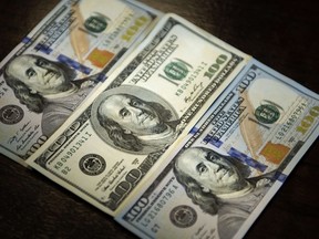 A view of a the new 2009 series $100 bill (centre) and the old 2006 series October 4, 2013 in Washington, DC. The new $100 bill will begin to go into circulation on October 8, and will include new security features such as a band with moving images, ink that changes color with the angle as well as a new design. AFP/Brendan SMIALOWSKI