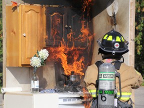 In this kitchen fire demonstration, firefighters extinguish a pot left to burn on the stove. (File photo)
