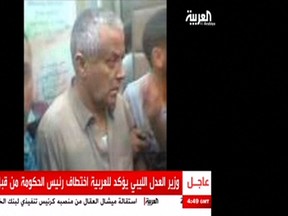 An undated still image aired by broadcaster Al Arabiya shows what it says is Libyan Prime Minister Ali Zeidan surrounded by men at an unidentified location. Gunmen from a former rebel faction kidnapped Zeidan on October 10, 2013 in reprisal for the government's role in the U.S. capture of a top al Qaeda suspect, shattering a fragile peace. (REUTERS/Al Arabiya via Reuters)
