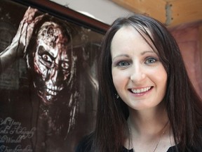 Horror makeup artist Leslie Wandell sits in front of a self-portrait she did of herself. She does face painting and bridal make-up but prefers the ghoulish side of her craft. (Michael Lea The Whig-Standard)