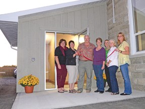 With Ewart McLaughlin, who along with his brother Ed was a vital contributor to the Dereham Centre Community Hall renovations, participated in a ribbon-cutting ceremony Tuesday night. With Ewart in front of the new entrance way are, from left, Marlene Spanjers, Brenda Prouse, Doris Grundy, Lorraine Garnham, Tess Thompson, and Carol VanMoerkerke. Also on the Dereham Centre Community Hall board are Ila MacLennan and Steve Garnham. CHRIS ABBOTT/TILLSONBURG NEWS/QMI AGENCY