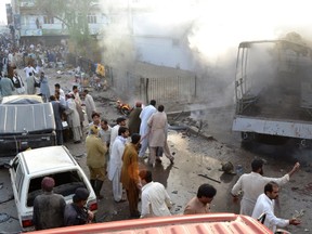 Residents, rescue workers and security officials gather at the site of a bomb blast in Quetta, Pakistan on Thursday. At least six people were killed and 35 people injured when a bomb exploded outside a police station in Quetta, the capital of Balochistan province, a police official confirmed and local media reported.
REUTERS/QMI Agency