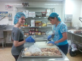 STEGH Executive Assistant Courtney Bell, left, and Mary Ellen Montanaro, from the kitchen staff, work together to prepare the turkey for Destination Church Thanksgiving supper. This is one of many initiatives underway at STEGH to support the United Way throughout the month of October. Contributed