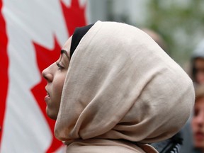 A demonstrator is framed by a Canadian flag as she protests against Quebec's proposed Charter of Values in Montreal, September 14, 2013.

Christinne Muschi/QMI Agency