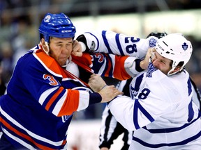 Edmonton Oilers Steve MacIntyre and Toronto Maple Leafs Colton Orr fight during first period during an NHL game between Toronto Maple Leafs and Edmonton Oilers in Toronto, December 2, 2010. Toronto Sun/QMI Agency