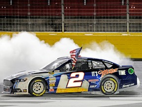 Brad Keselowski, driver of the No. 2 Miller Lite Ford, celebrates with a burnout after winning during the NASCAR Sprint Cup Series Bank of America 500 at Charlotte Motor Speedway on Saturday night. (AFP)