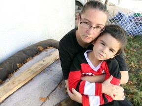 Tammy Jackson hugs her son Joshua near where their badly beaten cat "Tigger" was found in their back yard in Winnipeg, Man. Sunday October 13, 2013. 
BRIAN DONOGH/WINNIPEG SUN/QMI AGENCY