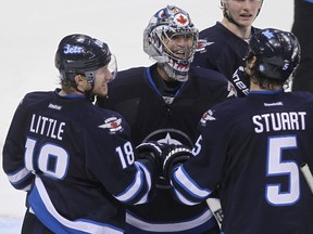 Winnipeg Jets goaltender Al Montoya (centre) celebrates a shutout in his first start of the season against the New Jersey Devils with Bryan Little (left) and Mark Stuart after NHL action at MTS Centre in Winnipeg, Man. on Sun., Oct. 13, 2013. Kevin King/Winnipeg Sun/QMI Agency