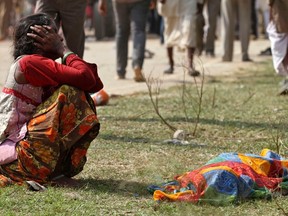 A woman cries next to the body of a victim killed in a stampede near Ratangarh temple, in Datia district in the central Indian state of Madhya Pradesh October 13, 2013. (REUTERS/Stringer)