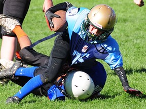 St. Thomas Hawk Luke Ainsworth scrambles for a little extra in the grasp of a Rampage defender Monday during London Minor Football Association play at Athletic Park. Ainsworth ran for a touchdown and kicked six converts as the Hawks won the peewee contest 48-6. R. MARK BUTTERWICK / St. Thomas Times-Journal / QMI AGENCY