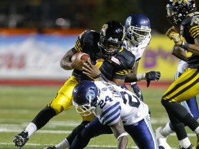Argonauts' Alonzo Lawrence and Tiger-Cats' Henry Burris mix it up during Monday's game at Alumni Stadium in  Guelph. (Ernest Doroszuk/Toronto Sun)