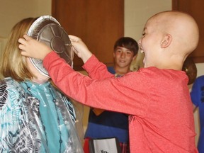Seven-year-old Carter Robbins shoves a pie in Principal Laurie Stephenson’s face during an assembly at Mooretown-Courtright Public School where this year’s Terry Fox fundraising total was announced. Together, the school’s students and staff raised $2,000 – double their goal – in honour of Carter, a cancer survivor.
