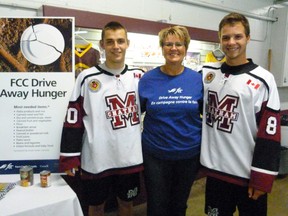 The Chatham Maroons hockey club and Farm Credit Canada undertook a food drive at their Oct. 13 game versus the Strathroy Rockets. Maroons Brendan Johnston, left, and Ben Pataki, team up with Lorrie Handsor of Farm Credit Canada, to get donations.