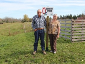 Albert and Valerie Chapleau proudly stand beside their Century Farms sign which designates their farm as 100 years old and actively own and run by one family, the Chapleau's.