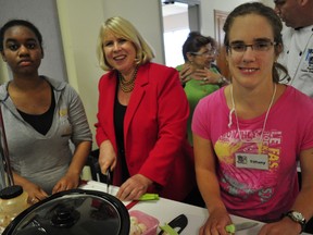 Brittney (left) and Tiffany (right), participants in an adaptive cooking class, were chopping vegetables with MPP Deb Matthews at the Church of St. Jude in London, Ont. October 16, 2013. Matthews announced an Ontario Trillium Foundation grant for the adaptive cooking classes, which were started by Londoners Brenda Ryan and Anne Robertson. CHRIS MONTANINI\LONDONER\QMI AGENCY