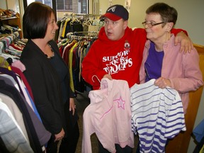 Sarah Coleman, left, who organized a clothing drive in her mother's memory to help stock a clothing store operated by Canadian Mental Health Association Elgin Branch, chats with Talbot Trends workers Joseph Evon and Patti Eggett. Oct. 18, 2013 (Eric Bunnell, Times-Journal)