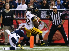 Ticats running back C.J. Gable, eluding the tackle of Argos' Jermaine Gabriel last Monday, says he notices opposing defences continually pointing him out and adjusting their alignments now that he has a had a few big games. (Dave Abel, Toronto Sun)