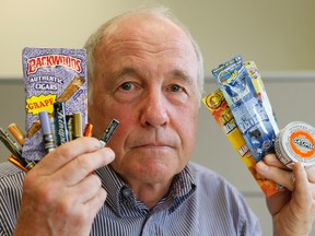 Michael Perley, of the Ontario Campaign for Action on Tobacco, holds up packaging of flavoured tobacco designed to attract young people  (Stan Behal/Toronto Sun)