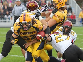 Queen's Ryan Granberg gets through traffic past Guelph's Jadon Johnson to gain yardage during Saturday afternoon's game at Richardson Field in Kingston on Saturday.
MICHAEL LEA\THE WHIG STANDARD\QMI AGENCY.