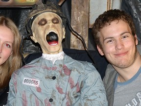 Melissa Hipperson, left, and Adam Michiels, right, are Glendale HS student volunteers helping set up Bob and Monica McCarey's Haunted House Tours. The man in the middle... he 'volunteered' to sit in the electric chair. CHRIS ABBOTT/TILLSONBURG NEWS