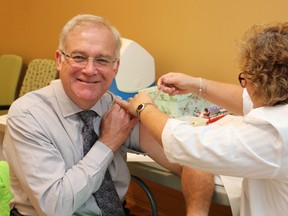 Bluewater Health's Dr. Mark Taylor gets his flu shot from Kathy Roswell at Sarnia's hospital recently. Bluewater Health staff are required this year to either be vaccinated against influenza or wear a mask while around patients during flu season. SUBMITTED/ FOR THE OBSERVER/ QMI AGENCY