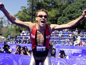 Simon Whitfield celebrates after winning the triathlon  gold medal at the Sydney Olympics in 2000. The Kingston-raised athlete announced on Tuesday that he was retiring from competing at the international level.
File photo