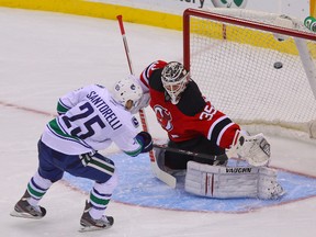 Canucks centre Mike Santorelli scores the game-winning goal on Devils goalie Cory Schneider during the shootout in Newark, N.J., on Thursday, Oct. 24, 2013. (Ed Mulholland/USA TODAY Sports)