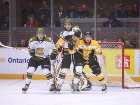 North Bay Battalion forwards Vincent Praplan, left, and Barclay Goodrow block the view of Kingston Frontenacs goalie Lucas Peressini while Frontenacs defenceman Roland McKeown defends against Goodrow during an Ontario Hockey League game in North Bay Thursday night. (Jennifer Hamilton-McCharles/QMI Agency)