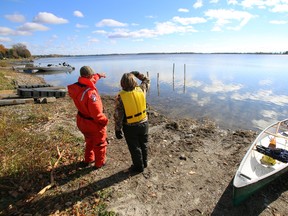 A family member of missing boater Sandy Rutherford points at the area on West Lake where the OPP and friends of the Wellington, Ont. resident have resumed the ongoing search Friday morning, Oct. 25, 2013. - JEROME LESSARD/The Intelligencer