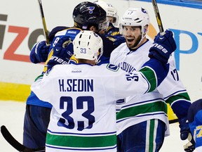 Canucks centre Ryan Kesler (right) is congratulated by Henrik Sedin after scoring the game-winning goal against the Blues in overtime at St. Louis on Friday, Oct. 25, 2013. (Jasen Vinlove/USA TODAY Sports)